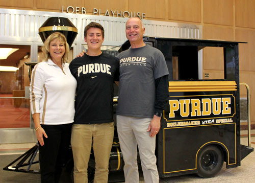 a student and parents posing in front of the Boilermaker Special